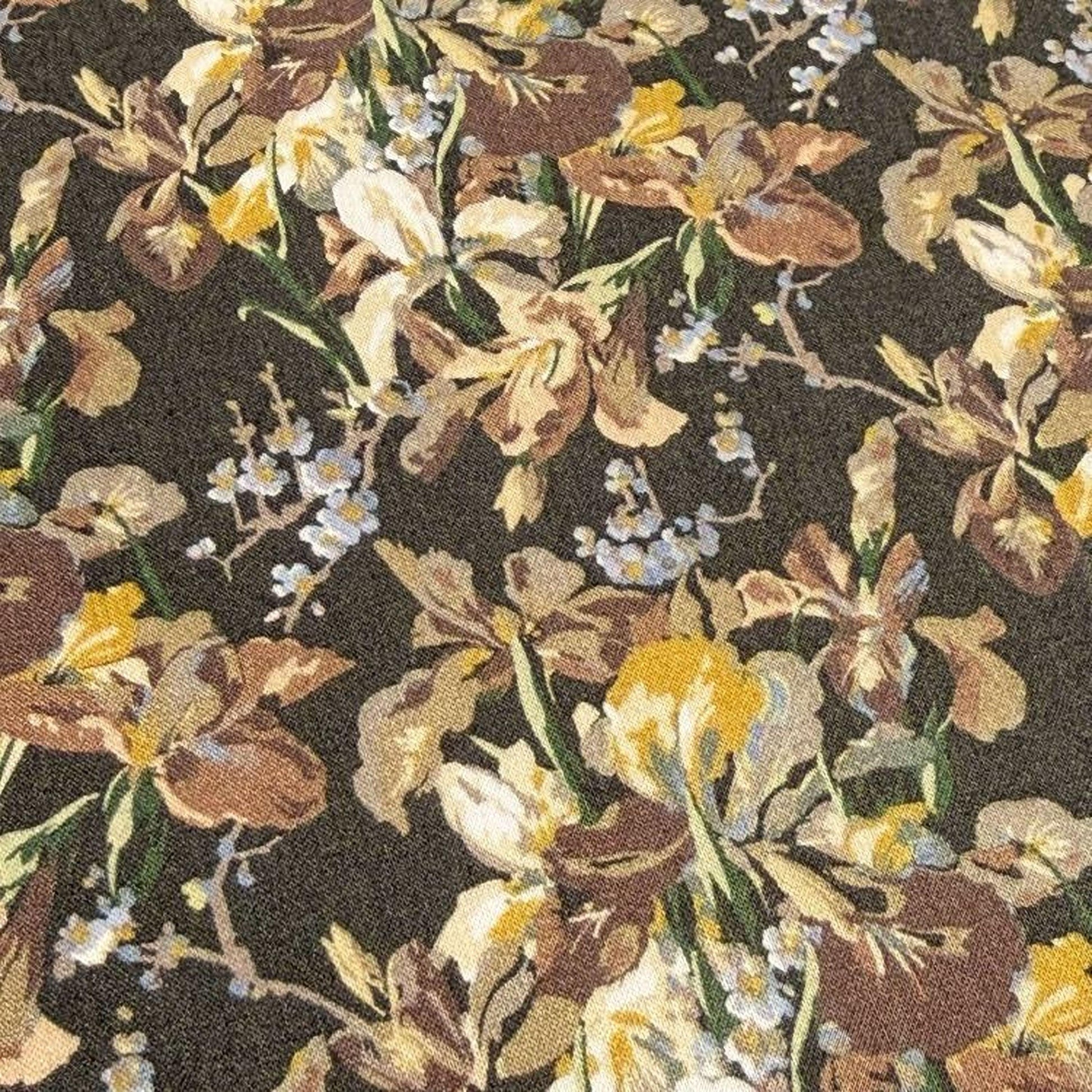 a close-up view of a fabric with a floral pattern. The fabric appears to be a dark-colored material with a variety of flowers in shades of yellow, brown, and white. The flowers are arranged in a way that creates a visually appealing and intricate design.