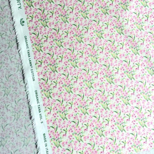 a close-up view of a fabric with a floral pattern in shades of pink and green. The fabric appears to be made of cotton and has a white label with text on it.