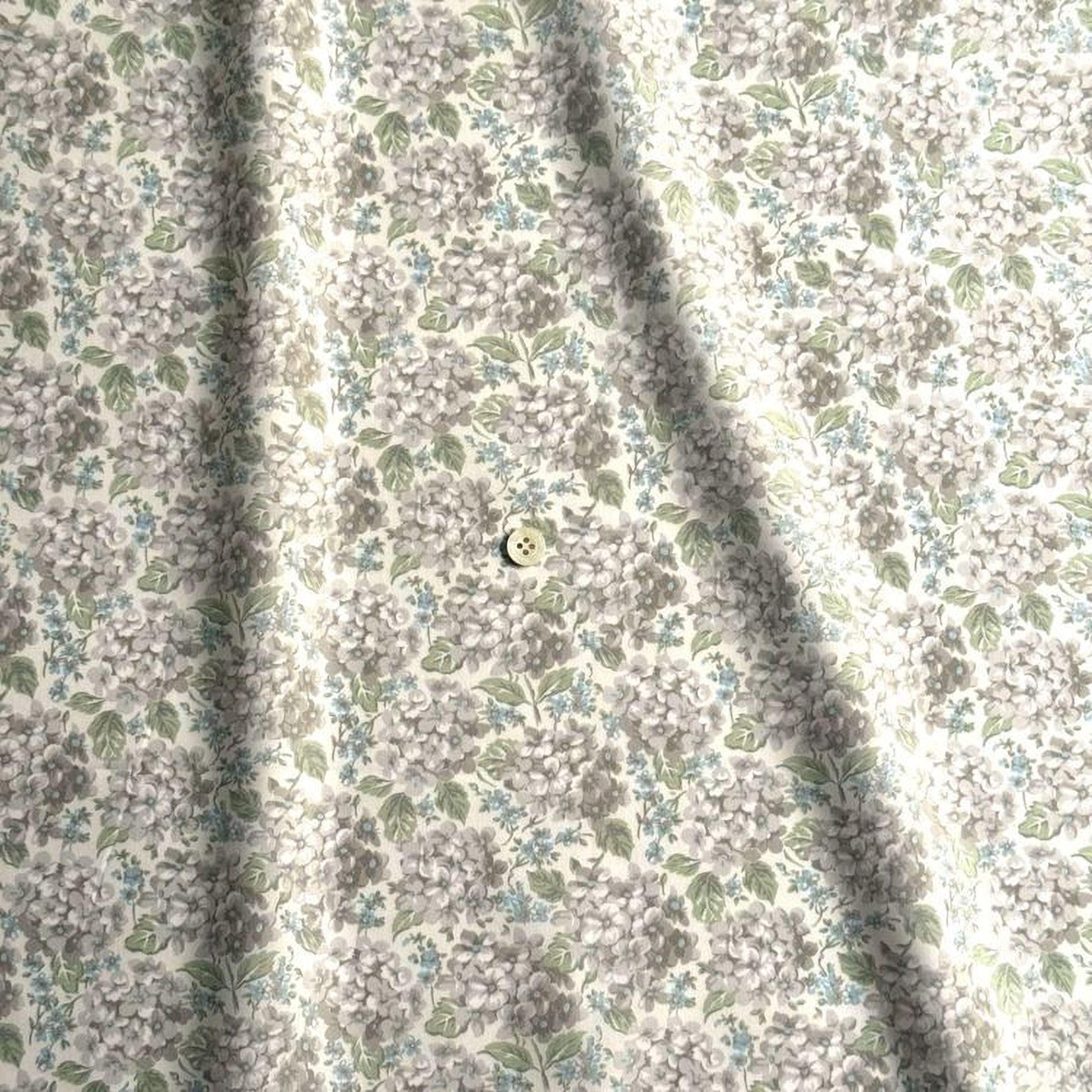 a close-up view of a fabric with a floral pattern, featuring a small button in the center.