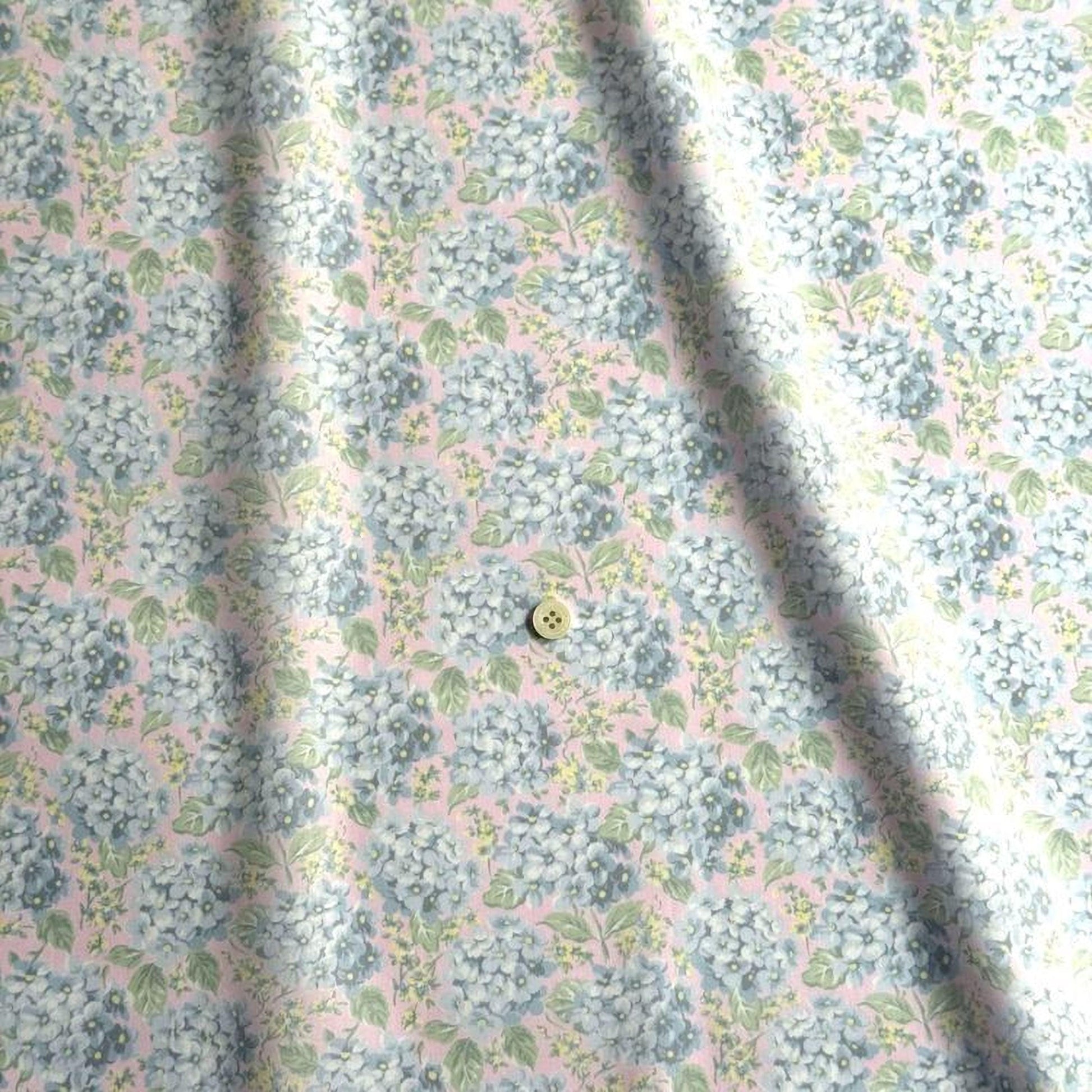 a close-up view of a fabric with a floral pattern, featuring a small button in the center.