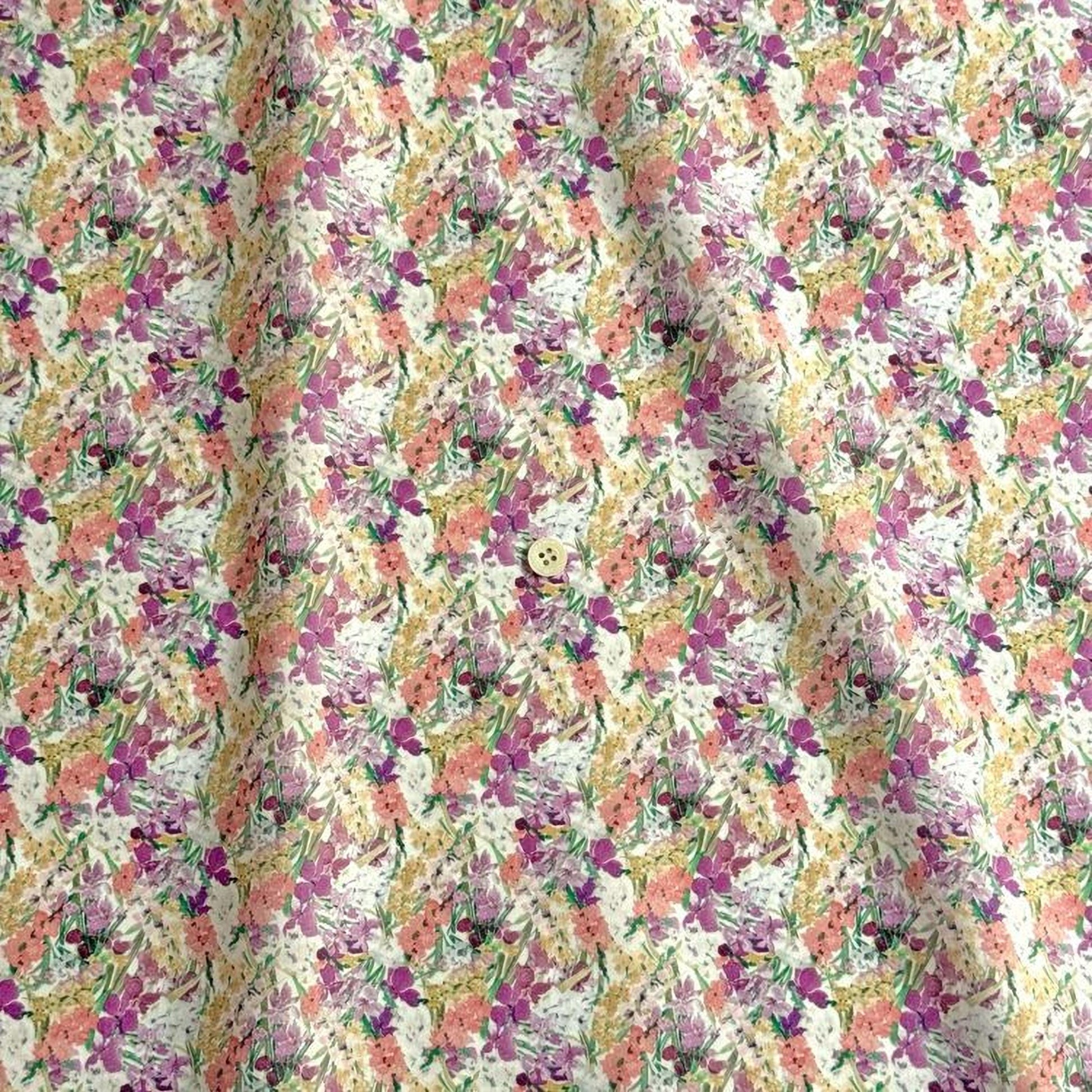 a fabric with a repeating floral pattern in shades of pink, yellow, and white. The pattern is composed of various flowers and leaves, creating a visually appealing and vibrant design.