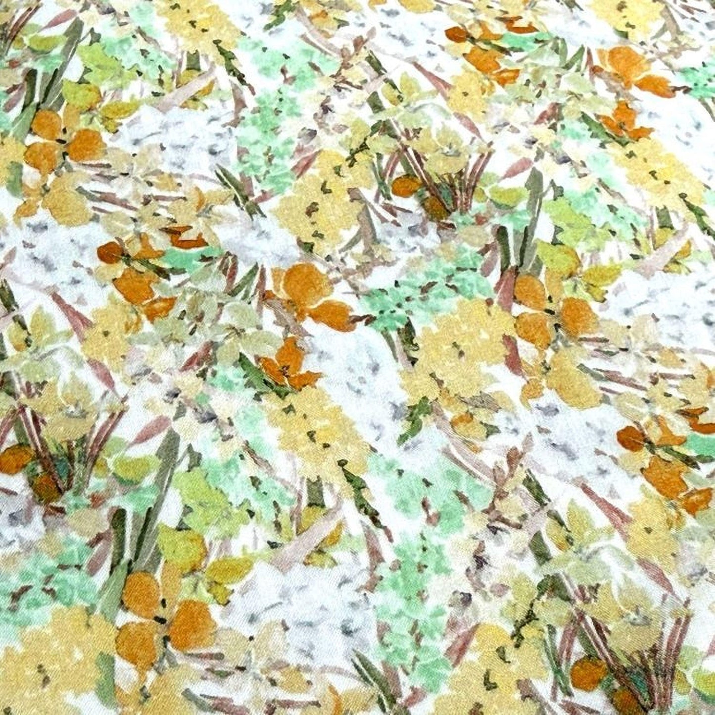 The image is a close-up of a fabric with a floral pattern, featuring a variety of colors including yellow, green, and orange.