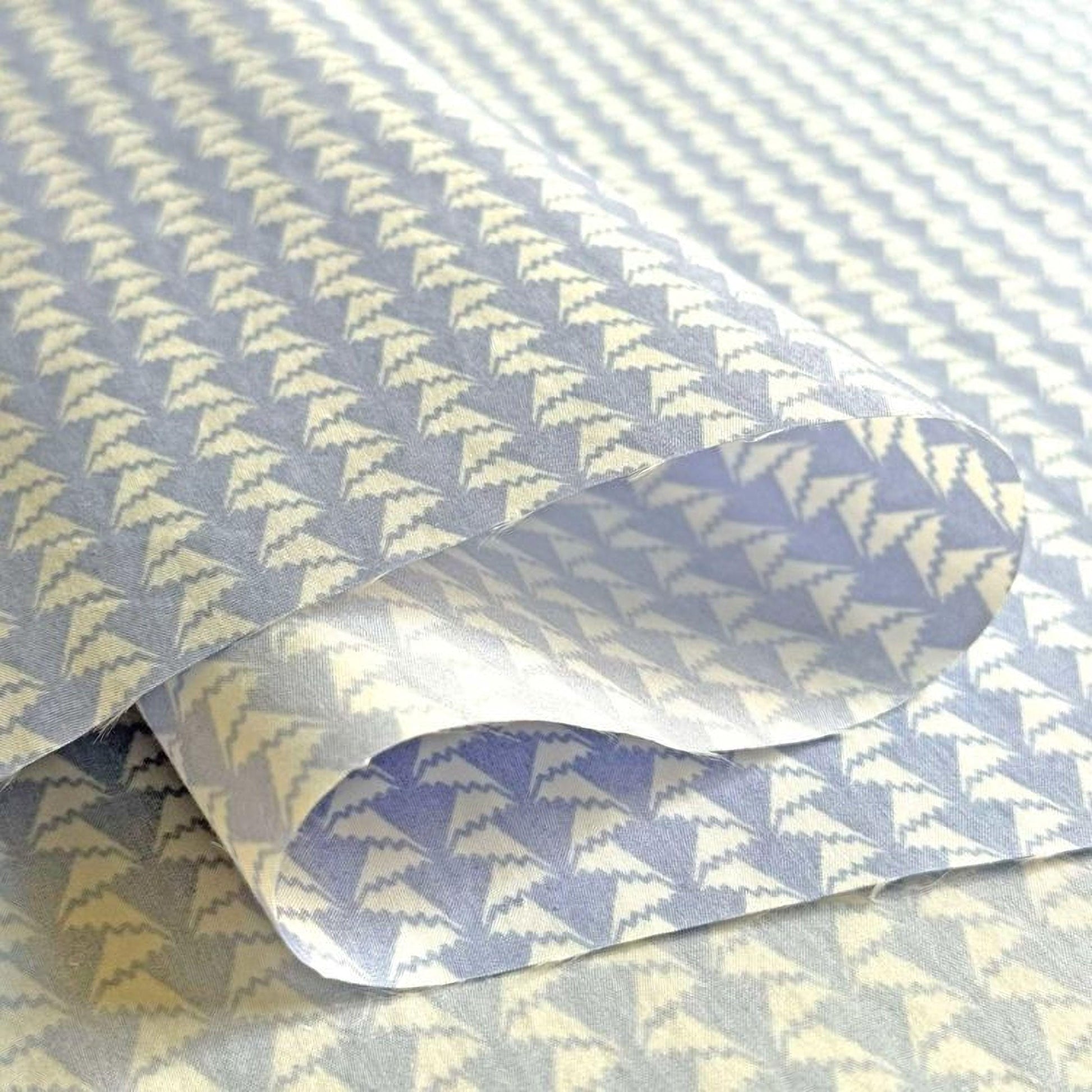 a close-up view of a piece of paper with a repeating pattern of blue and white triangles.