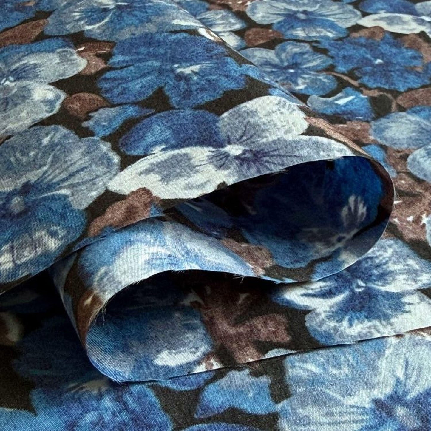 a close-up view of a fabric with a floral pattern in shades of blue and brown.