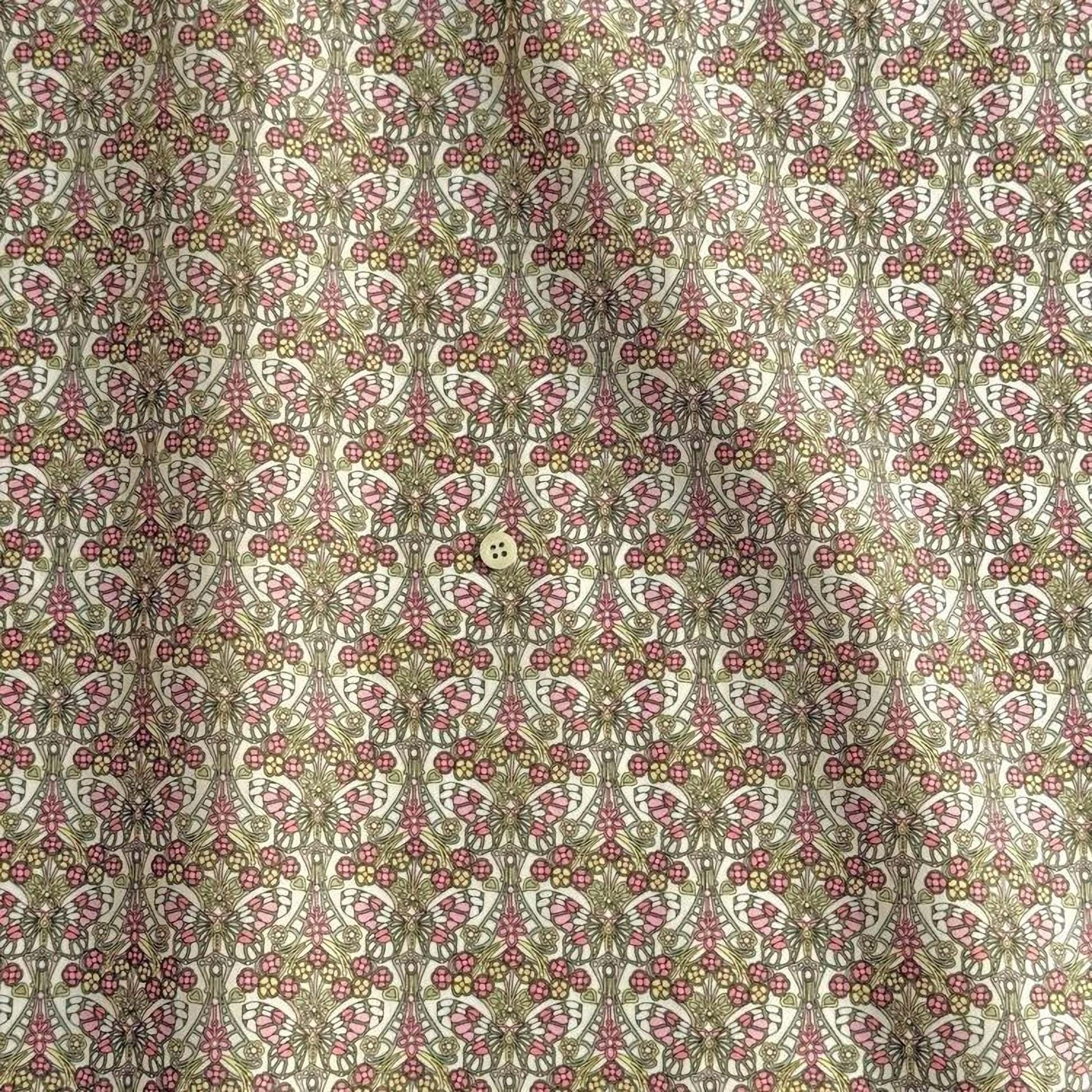 a repeating pattern of a floral design in shades of pink and green, with a small button visible in the center.