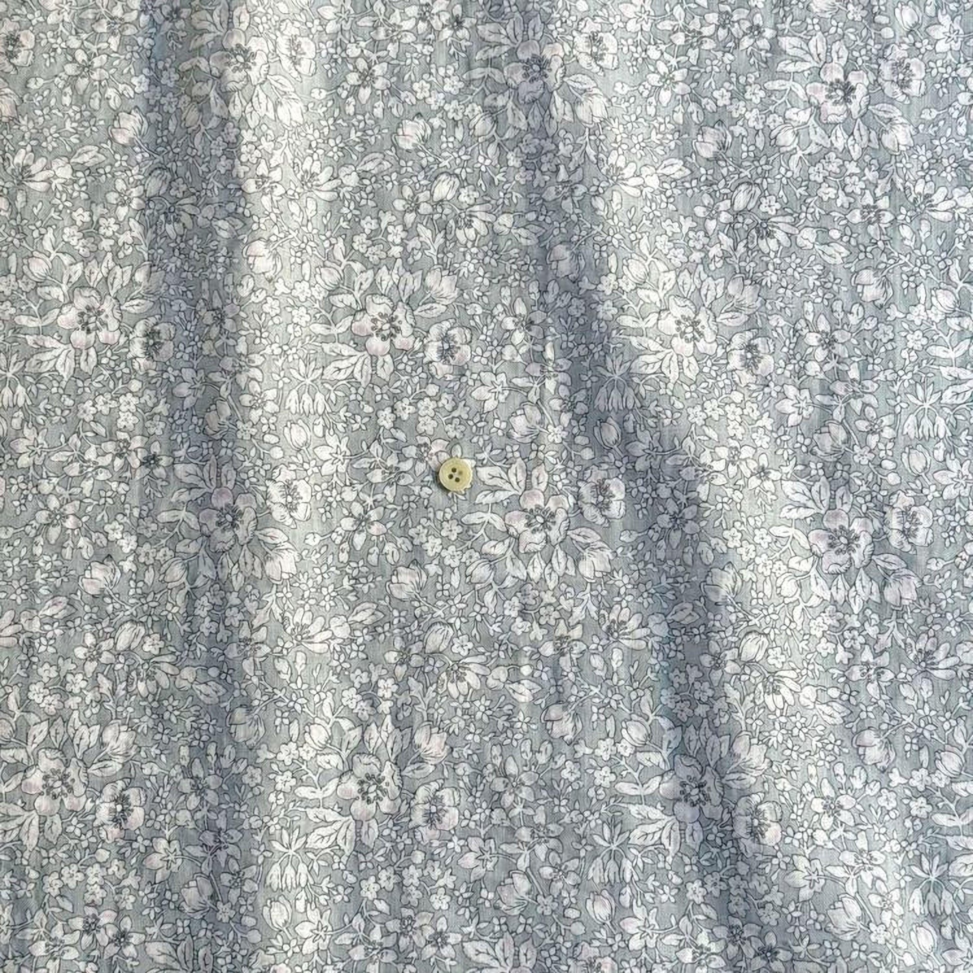 a close-up view of a fabric with a floral pattern, featuring a small button in the center.