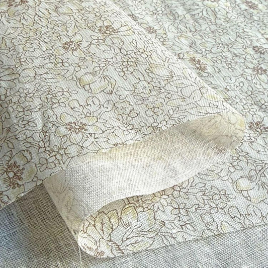a close-up view of a fabric with a floral pattern, featuring a mix of brown and white colors.