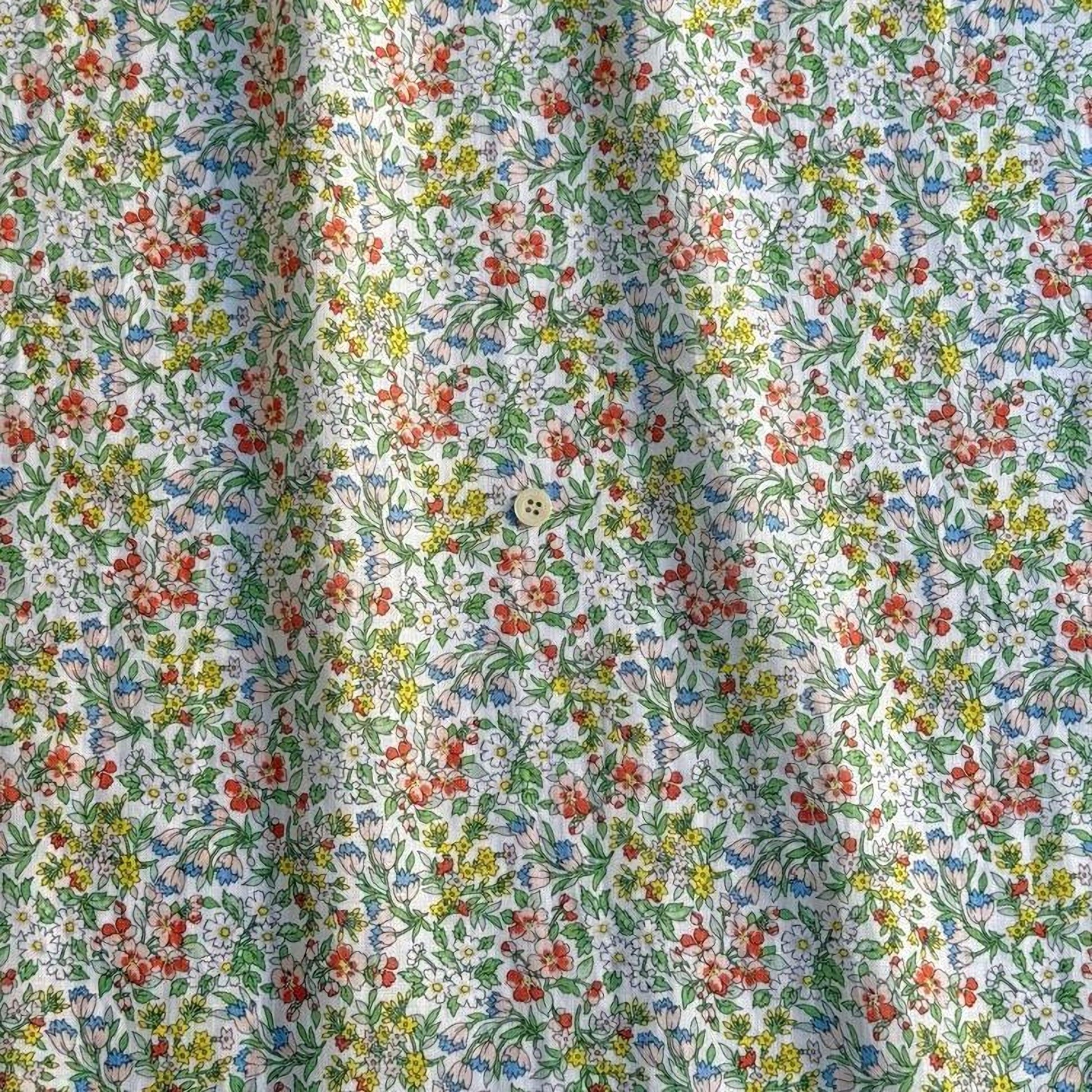 a close-up view of a fabric with a floral pattern, featuring a variety of colorful flowers and leaves.