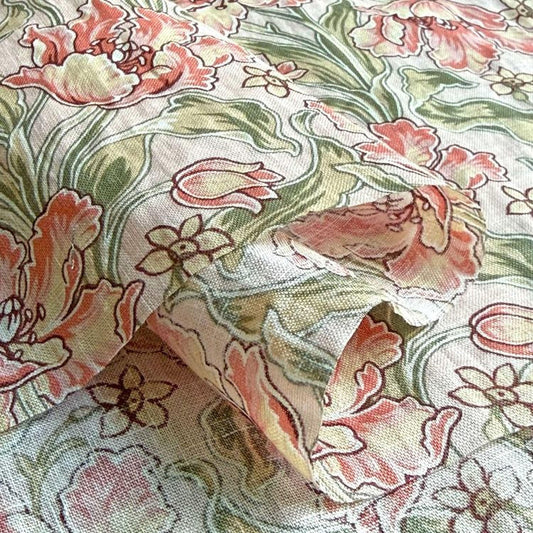 a close-up view of a fabric with a floral pattern, featuring a variety of pink and green flowers and leaves.