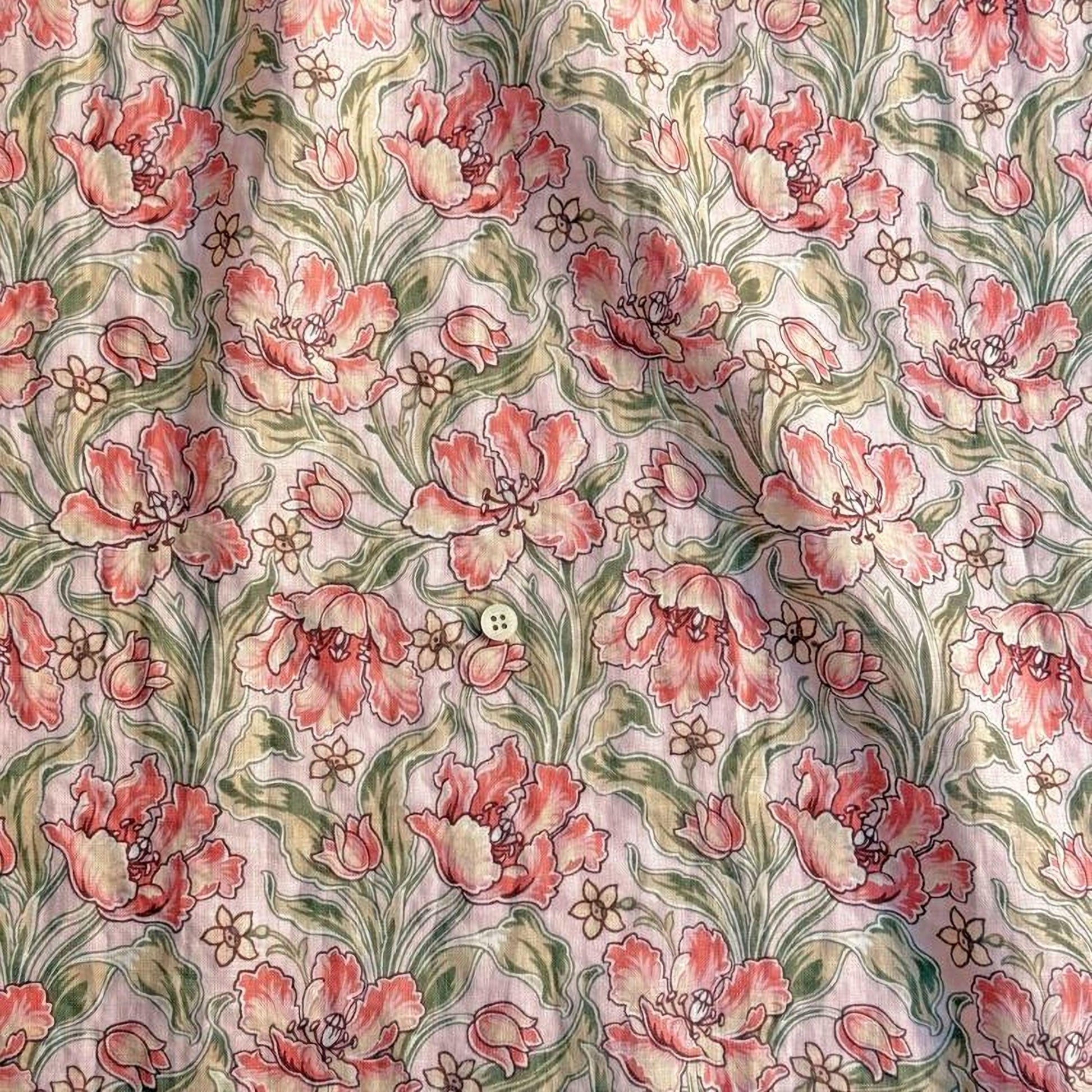 a close-up view of a fabric with a floral pattern. The pattern consists of pink flowers with green leaves, creating a visually appealing and intricate design. The fabric appears to be a light pink color, which complements the pink flowers and green leaves. The pattern repeats itself across the fabric, creating a sense of continuity and rhythm. The image does not contain any text or other objects, and the focus is solely on the floral pattern.