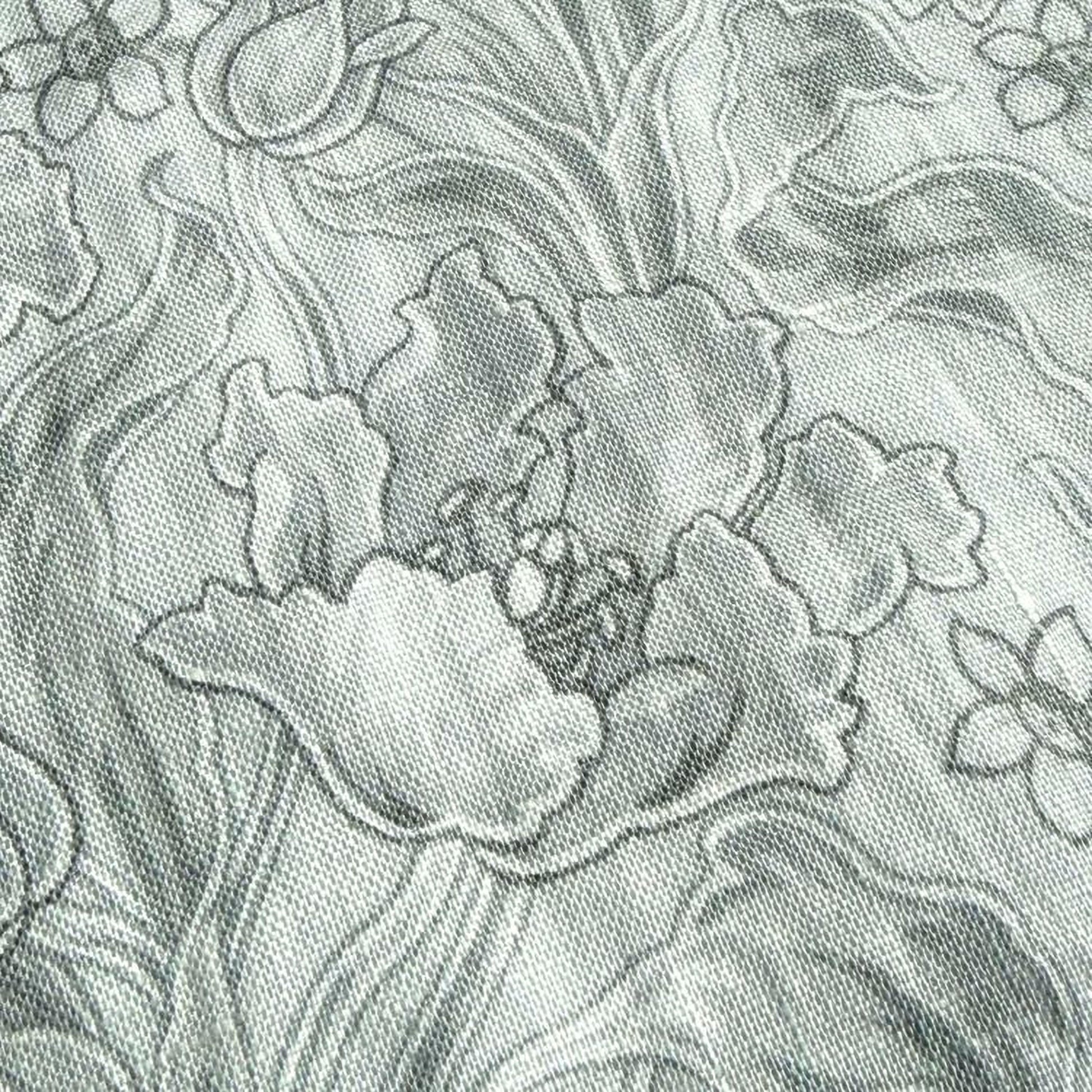 The image is a close-up of a fabric with a floral pattern, featuring a variety of flower shapes and sizes.