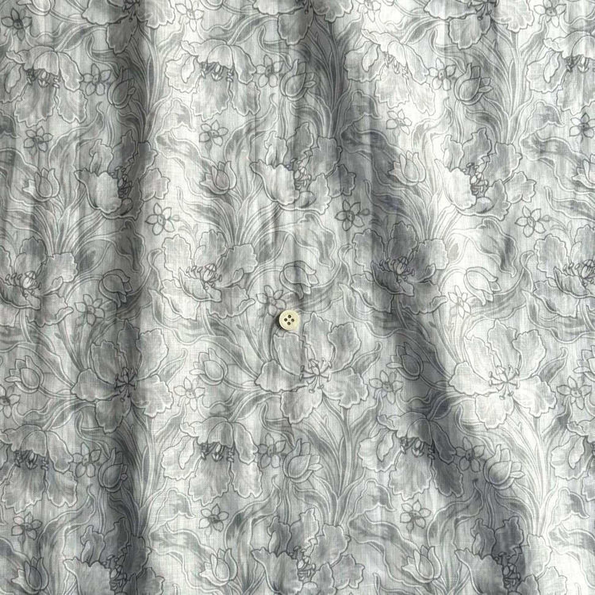 a close-up view of a fabric with a floral pattern, featuring a single button in the center.