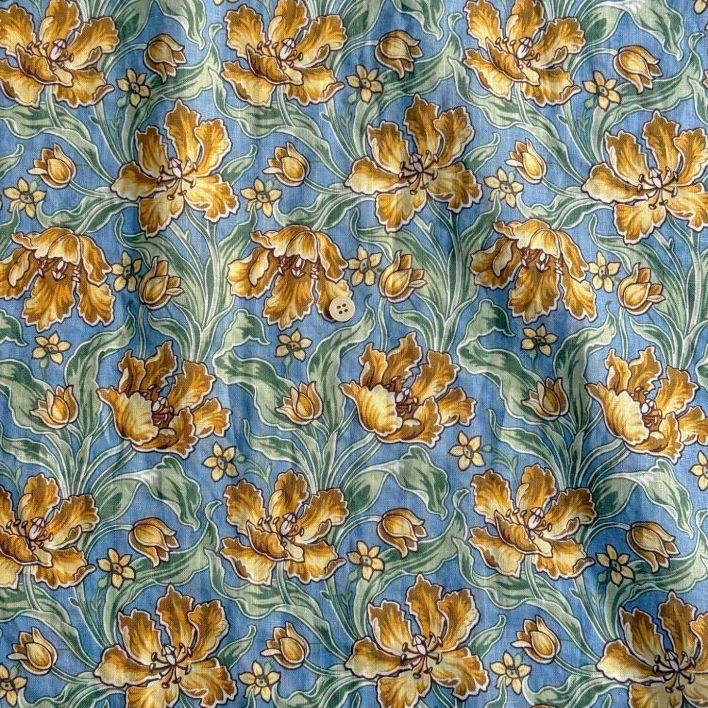 a repeating pattern of yellow flowers with green leaves against a blue background.