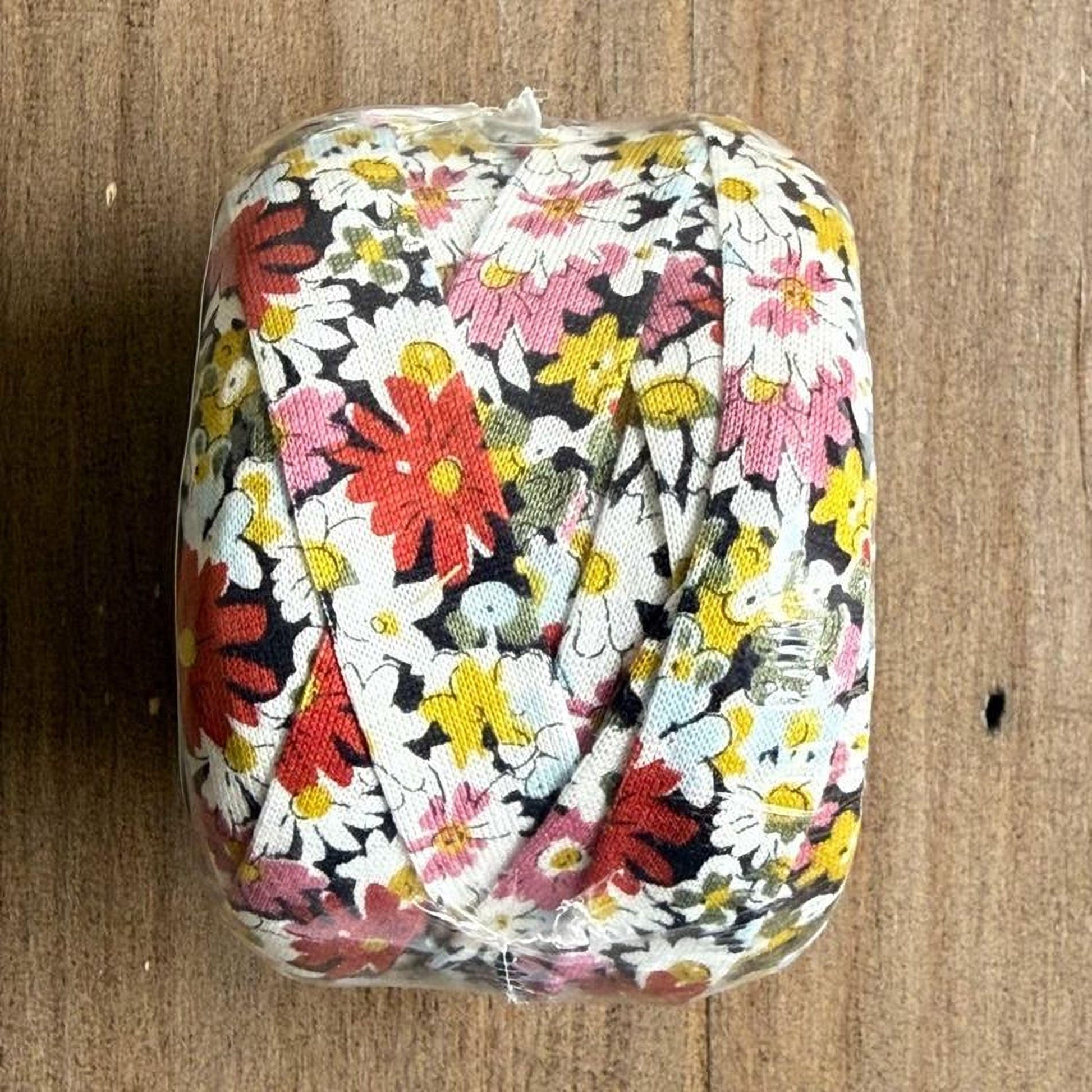 A clear plastic bag containing a colorful floral pattern, with the flowers depicted in shades of red, yellow, and white.