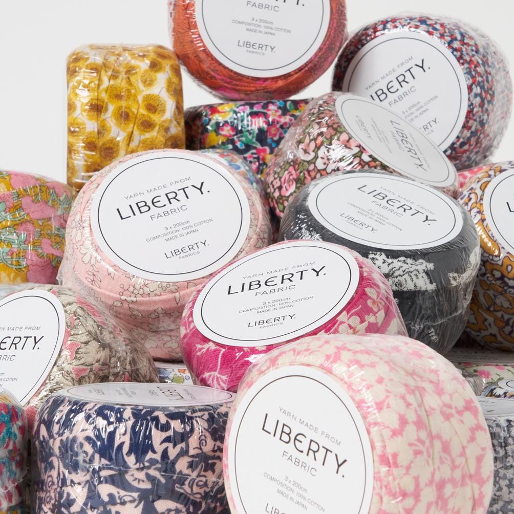 various fabric swatches and containers labeled "Liberty Fabric" in a visually appealing arrangement.