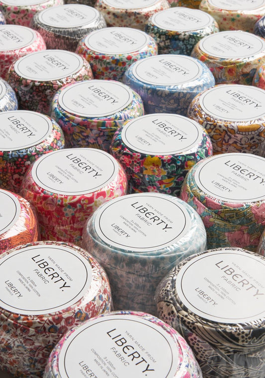 a collection of colorful fabric containers with labels that read "LIBERTY". The containers are arranged in rows, with some overlapping each other.