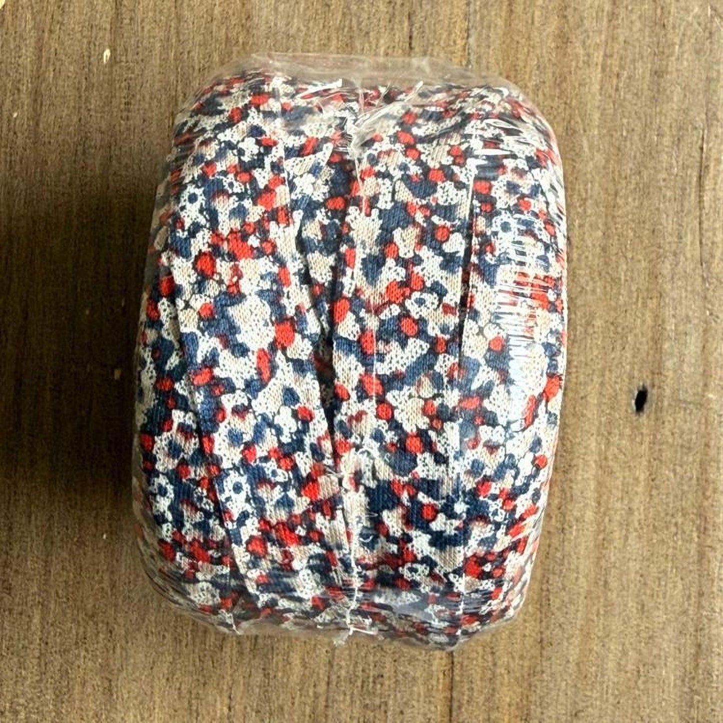 A clear plastic bag filled with red, white, and blue fabric or material, possibly a decorative piece or a textile product.