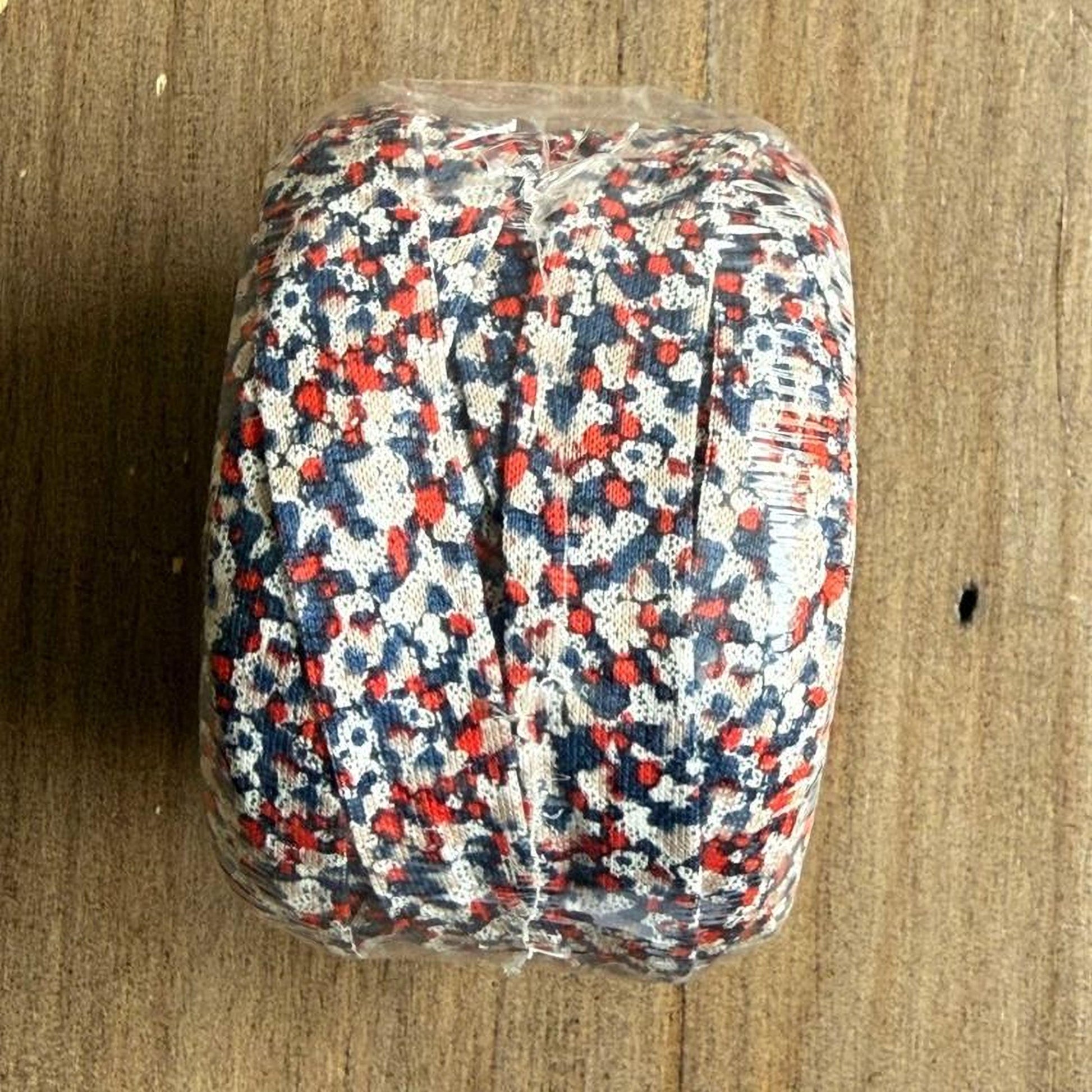 A clear plastic bag filled with red, white, and blue fabric or material, possibly a decorative piece or a textile product.