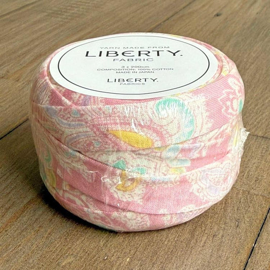 A spool of yarn made from Liberty fabric, with a label indicating it is 3.2 yards in length and made in Japan.