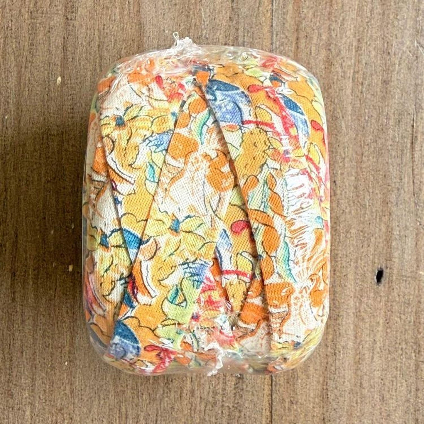 A clear plastic bag containing a colorful fabric with a floral pattern.