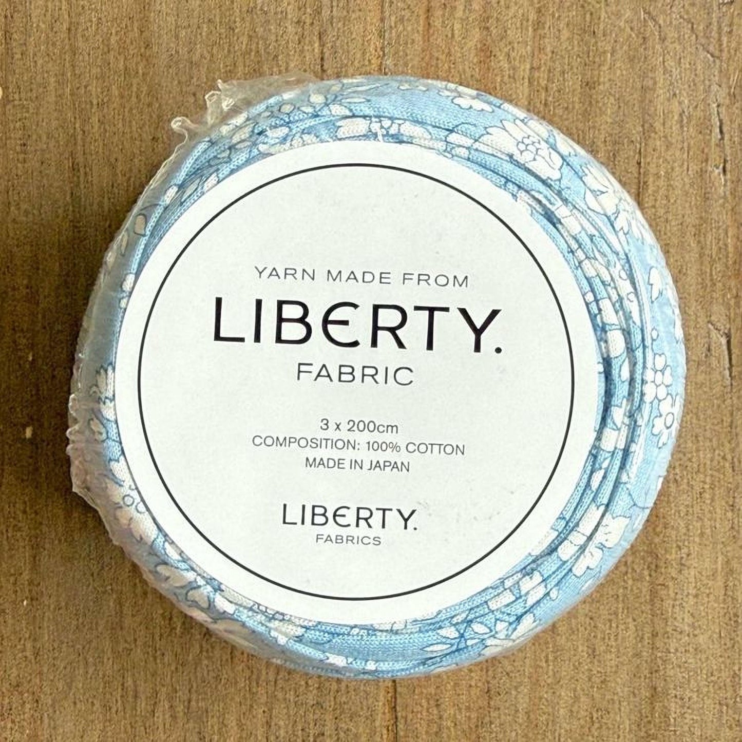 A label for a fabric product, specifically a spool of yarn made from the fabric.