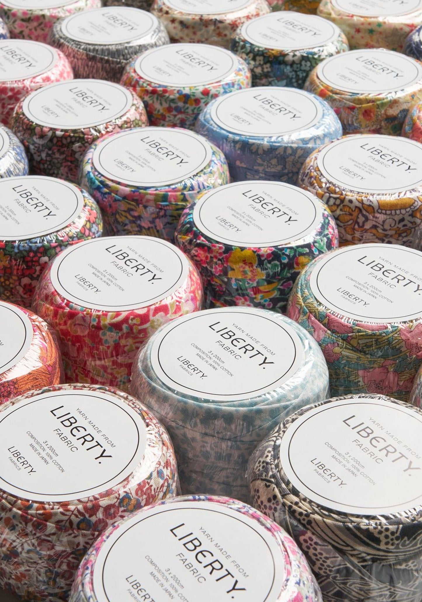 a collection of colorful fabric candles arranged in rows, each with a label that reads "LIBERTY".