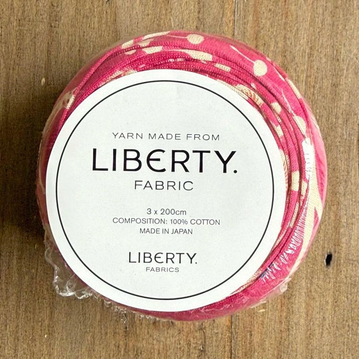 A package of yarn made from Liberty fabric, with a label indicating it is composed of 100% cotton and made in Japan.