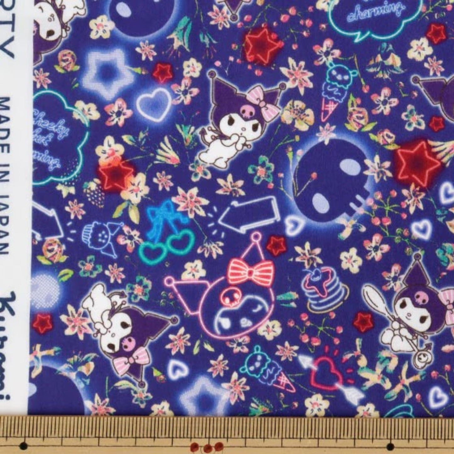 The image is a vibrant and colorful fabric print featuring various cartoon-like characters and floral patterns in shades of blue, purple, and pink.