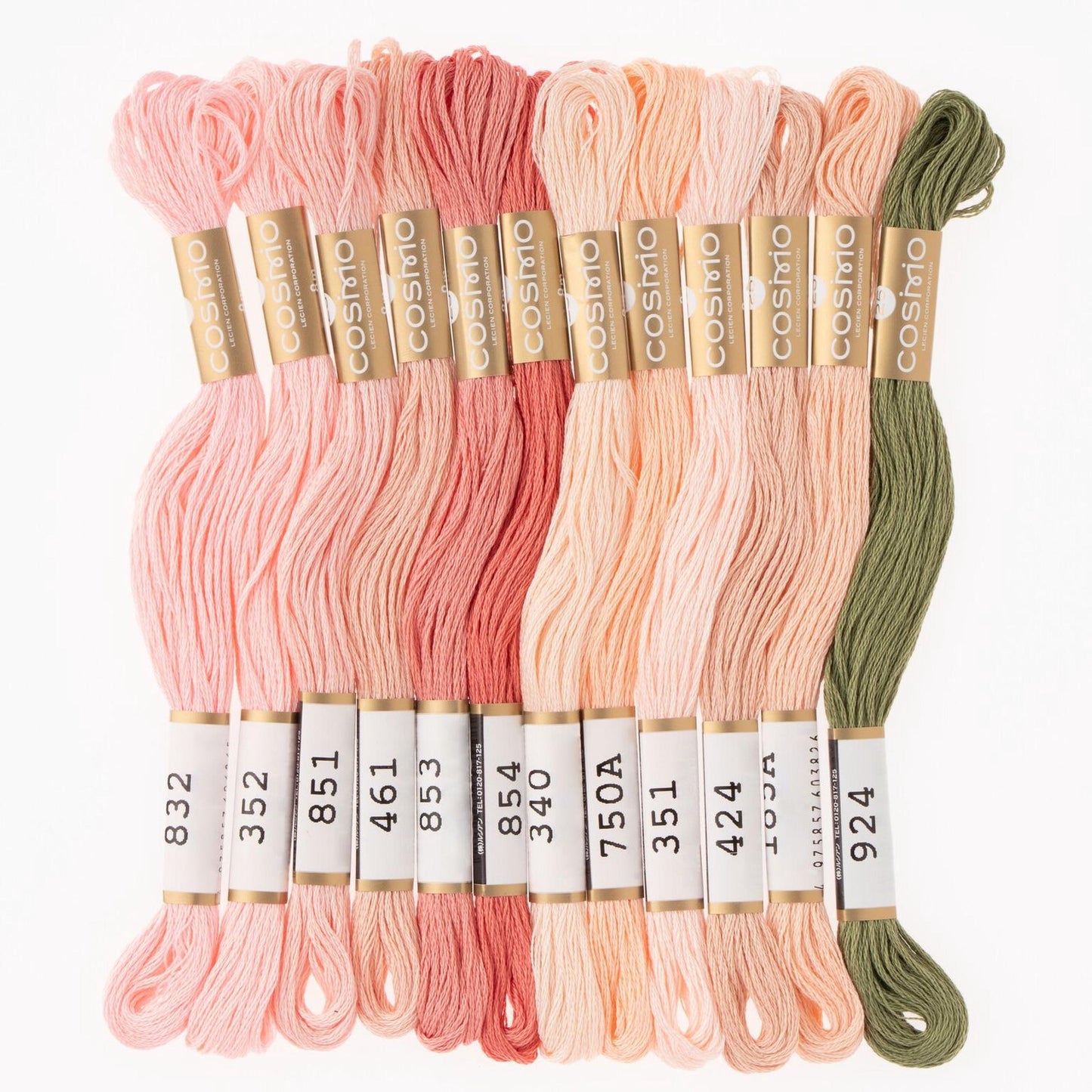 A collection of various colored embroidery floss threads, including pink, peach, green, and other pastel shades, arranged in rows.