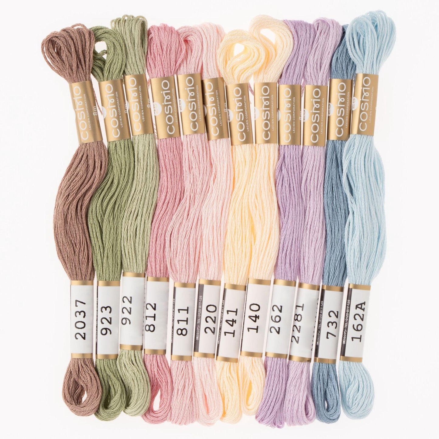 A collection of colorful spools of thread in various pastel shades, including mint, lavender, peach, and blue, arranged in a row.