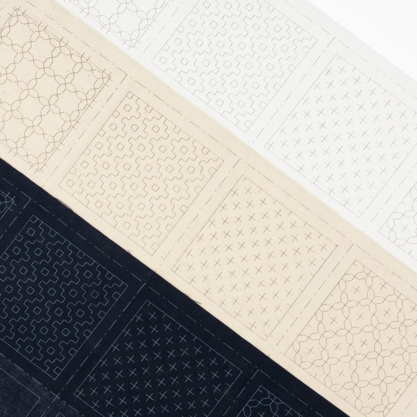 The image is a collage of three different patterns, each with a unique design and color scheme. The patterns include a black and white geometric design, a beige geometric design, and a black and white floral design. The patterns are arranged in a diagonal line, creating a visually striking and dynamic composition.