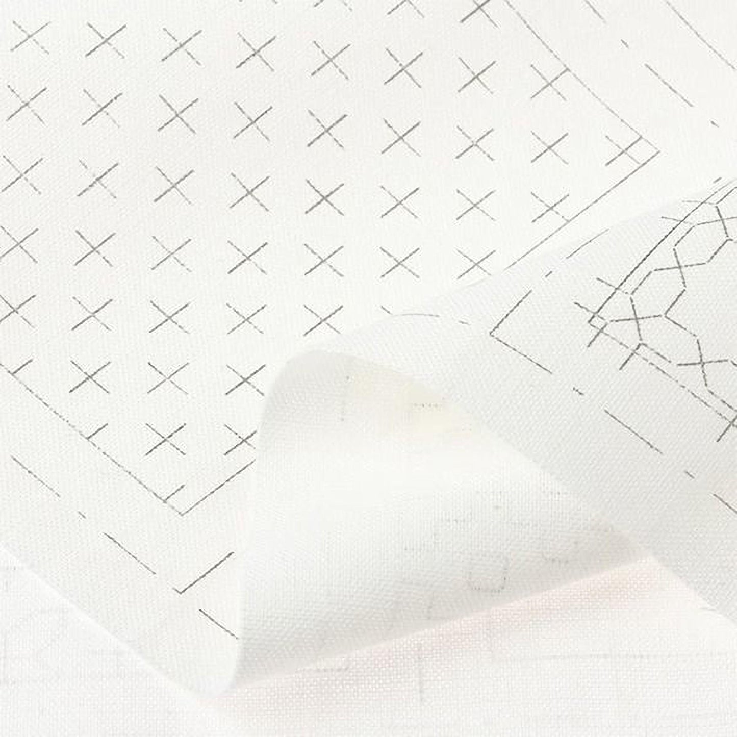The image is a close-up of a white fabric with a grid pattern of black crosses.
