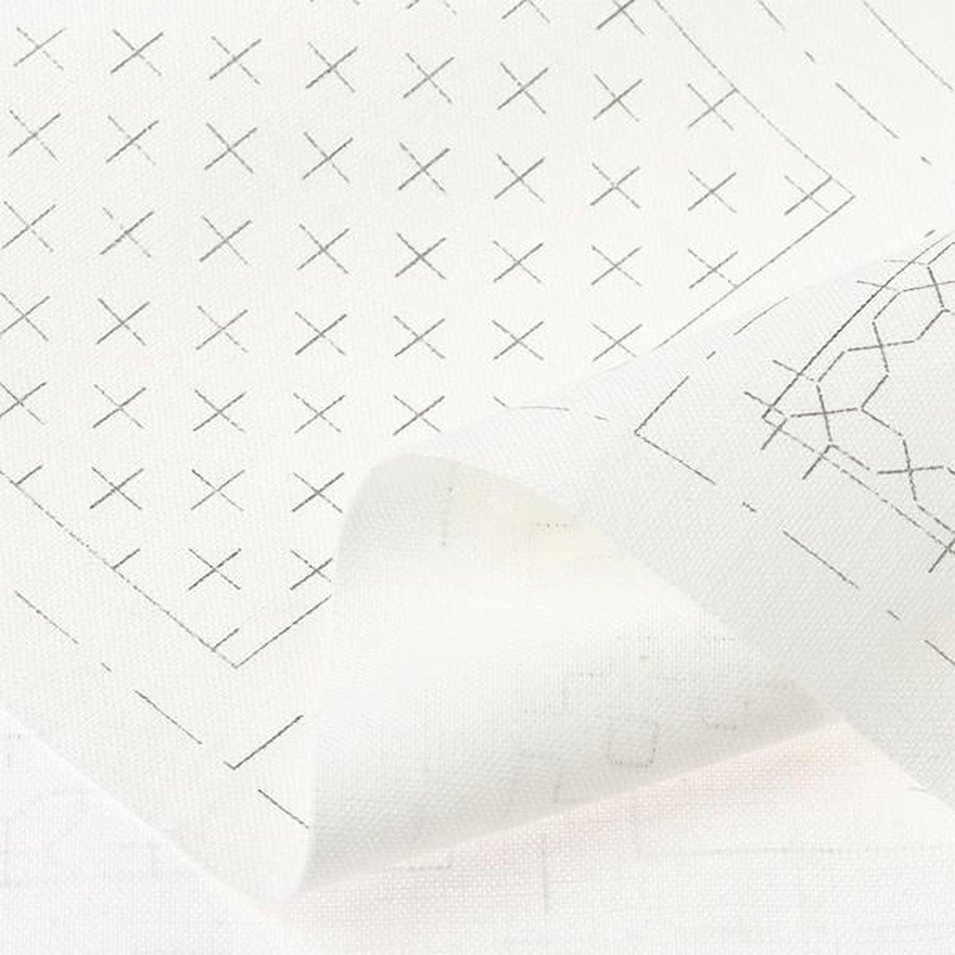 The image is a close-up of a white fabric with a grid pattern of black crosses.