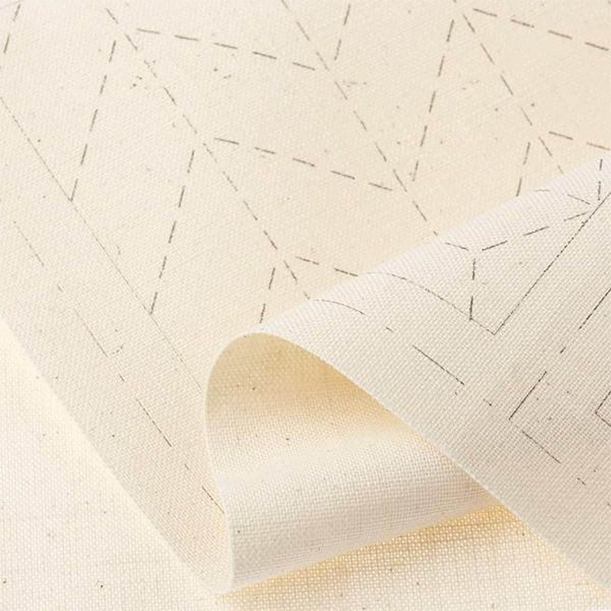 a close-up view of a piece of white fabric with a geometric pattern, possibly a piece of embroidery or a textile.