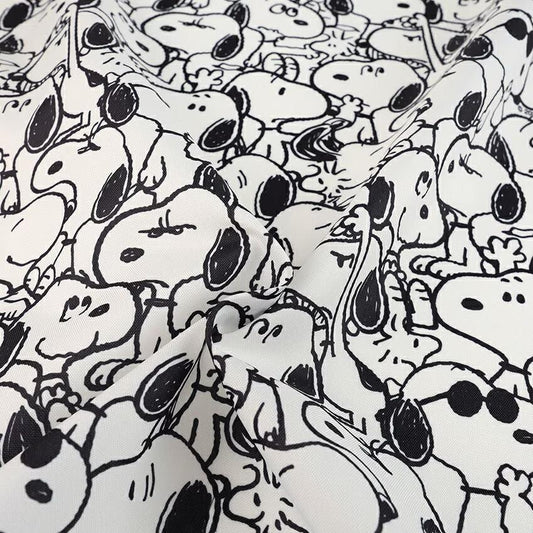 The image is a close-up of a fabric with a repeating pattern of cartoon-style Snoopy dogs.