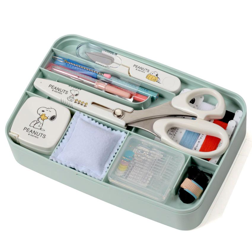 A light green storage container filled with various office and craft supplies, including scissors, pens, and other tools.