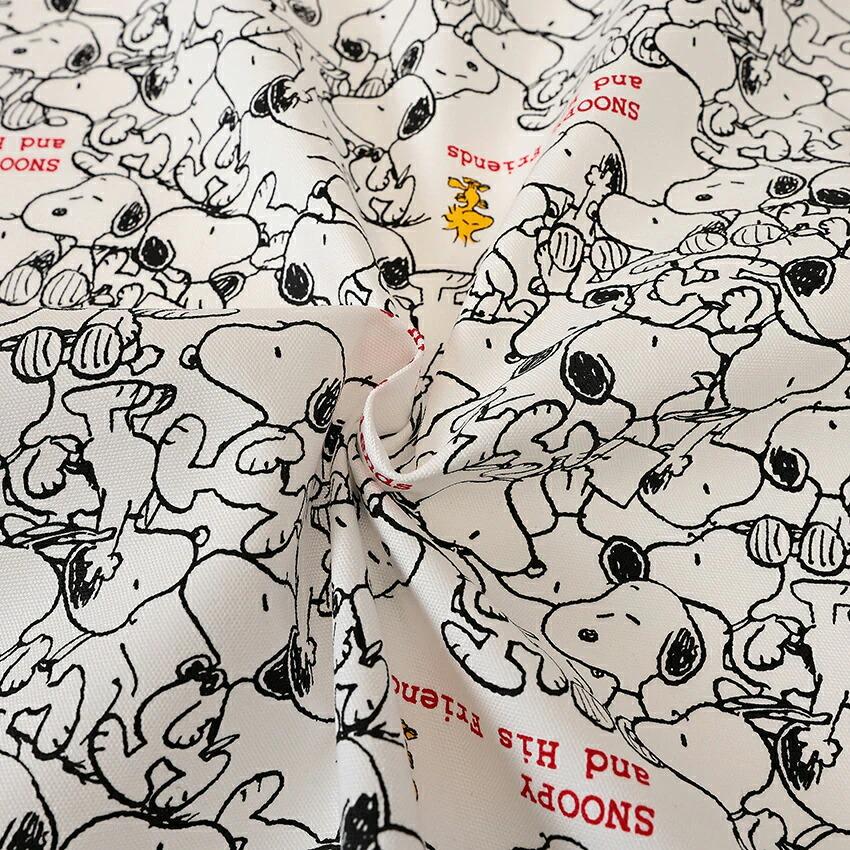 The image is a close-up of a fabric with a repeating pattern of cartoon characters, specifically the character Snoopy. The pattern consists of multiple Snoopy illustrations arranged in a visually appealing manner, creating a vibrant and playful design.