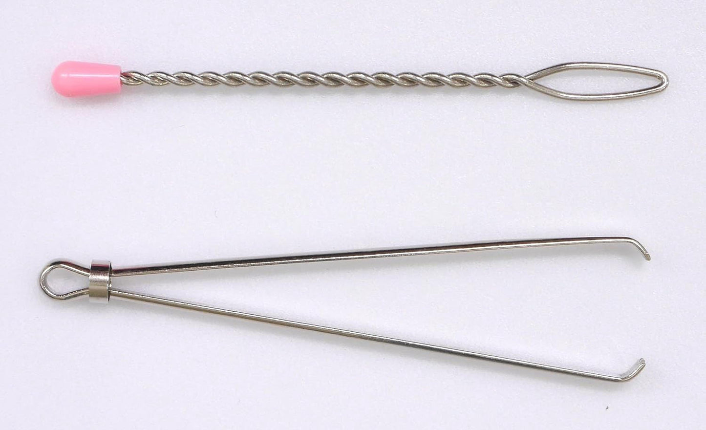 two metal tools, one with a pink cap and the other with a twisted metal handle, both lying on a white background.