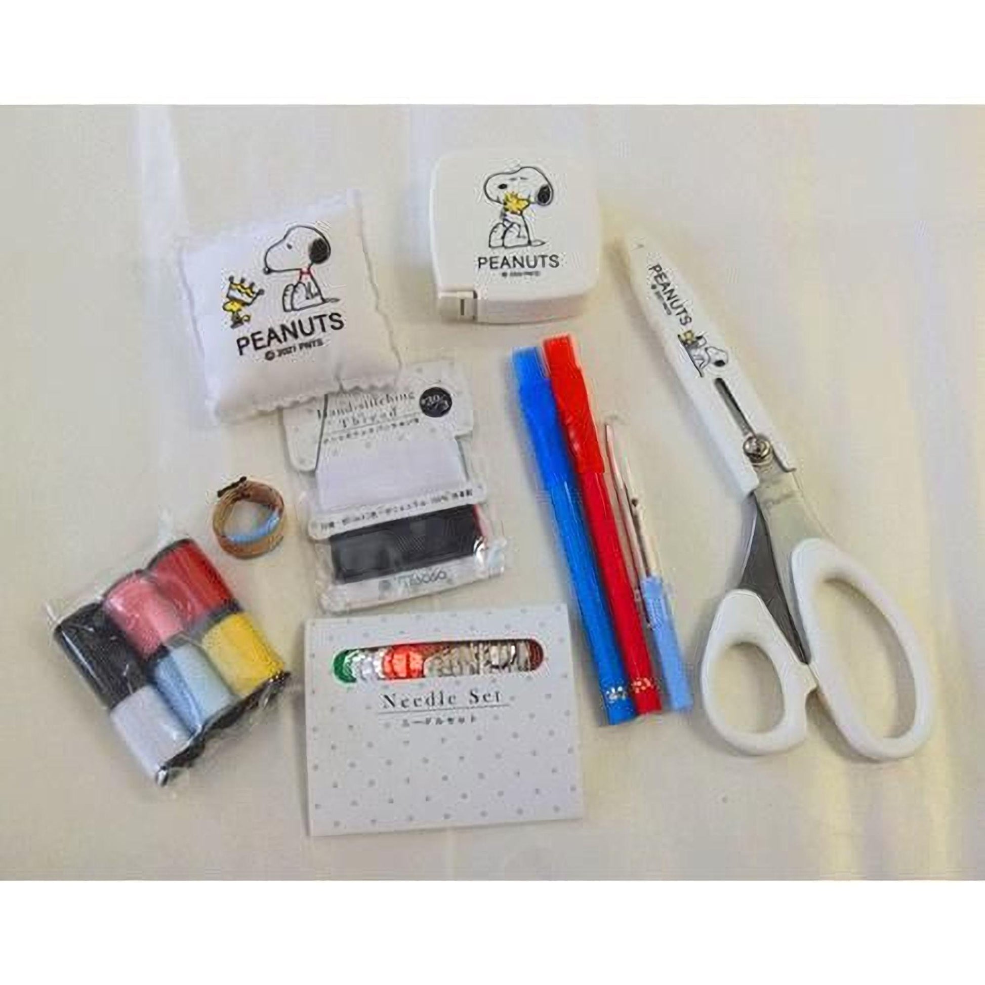various sewing and crafting supplies, including a pair of scissors, a needle, thread, and other tools.