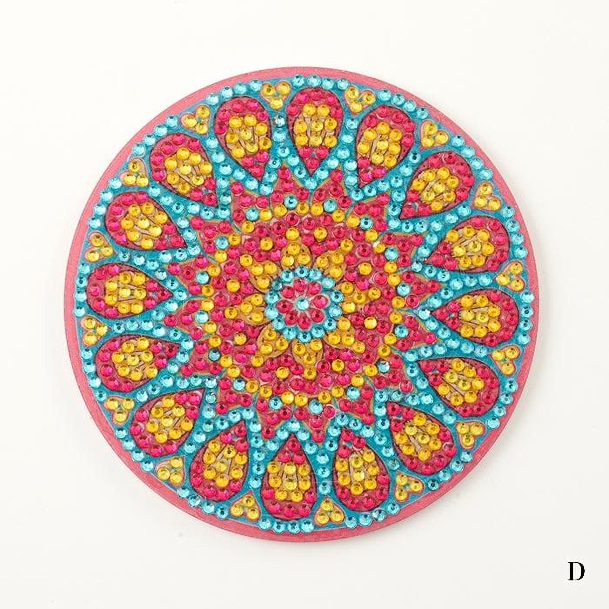 A colorful, circular coaster with a vibrant, intricate design featuring a central motif surrounded by a pattern of overlapping shapes in various colors, including pink, yellow, blue, and green.