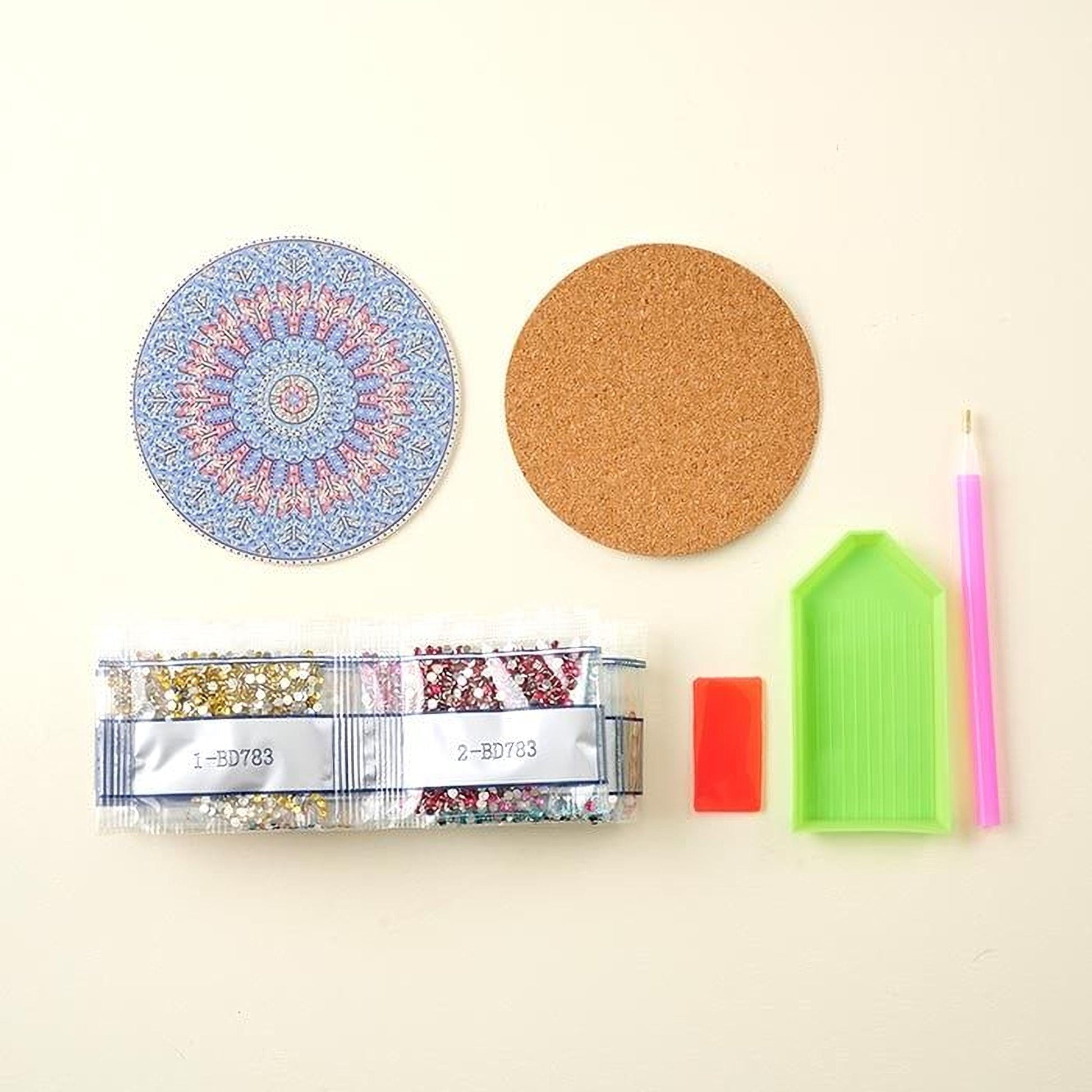 various craft supplies, including a cork coaster, a pen, a small plastic container, and a set of beads.