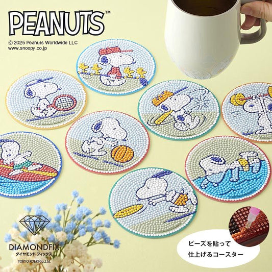 a collection of Peanuts-themed coasters, each depicting a different Peanuts character engaged in various activities. The coasters are arranged on a light yellow background, and there is a cup of coffee visible in the top right corner.