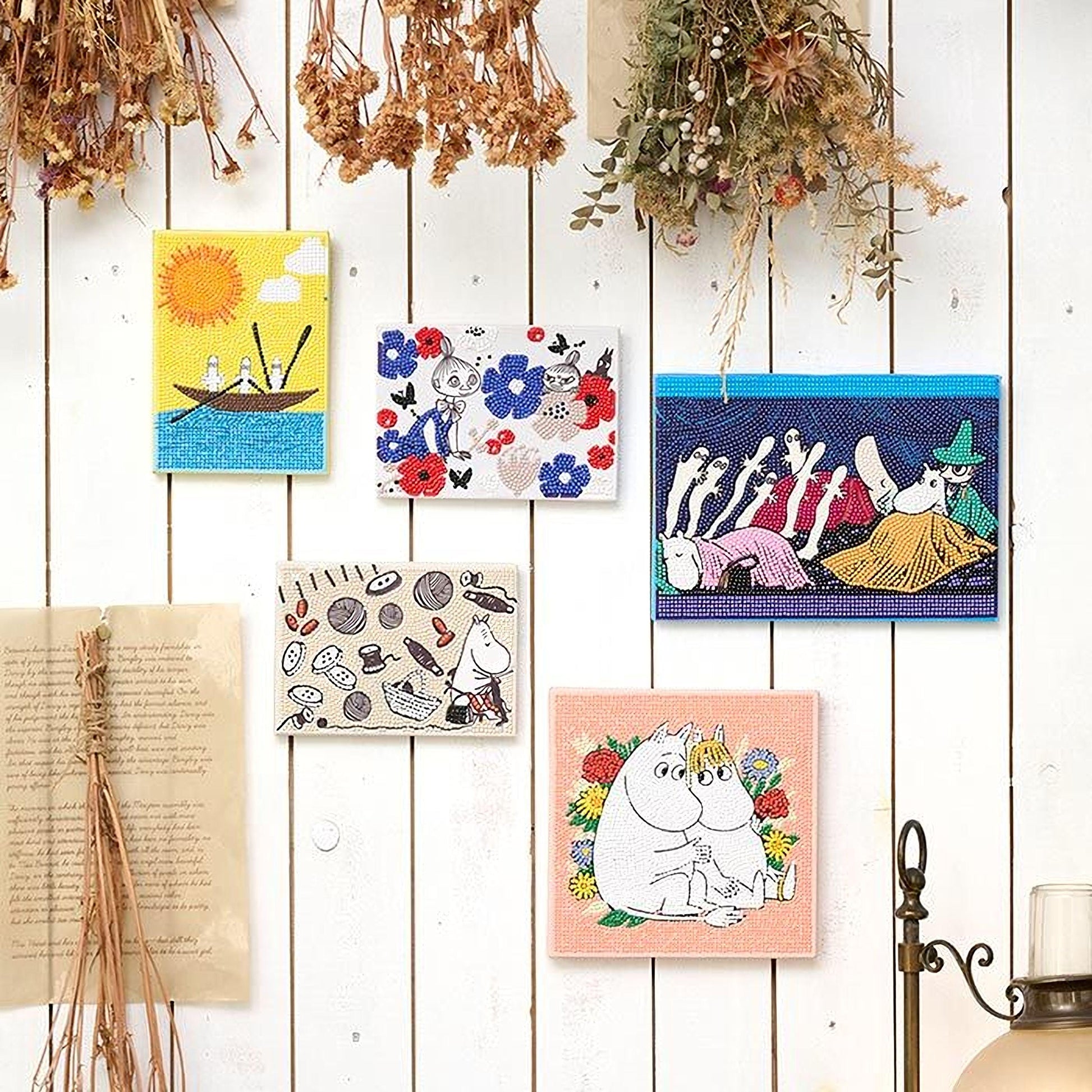 a collection of colorful and whimsical artworks, including paintings and illustrations, displayed on a white wall.