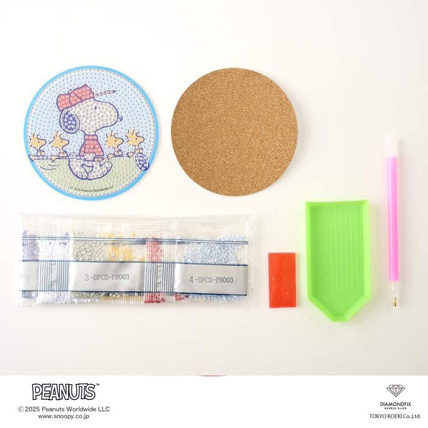 various Peanuts-related items, including a Peanuts-themed coaster, a cork coaster, a pen, a magnifying glass, a magnifying glass, and a magnifying glass.