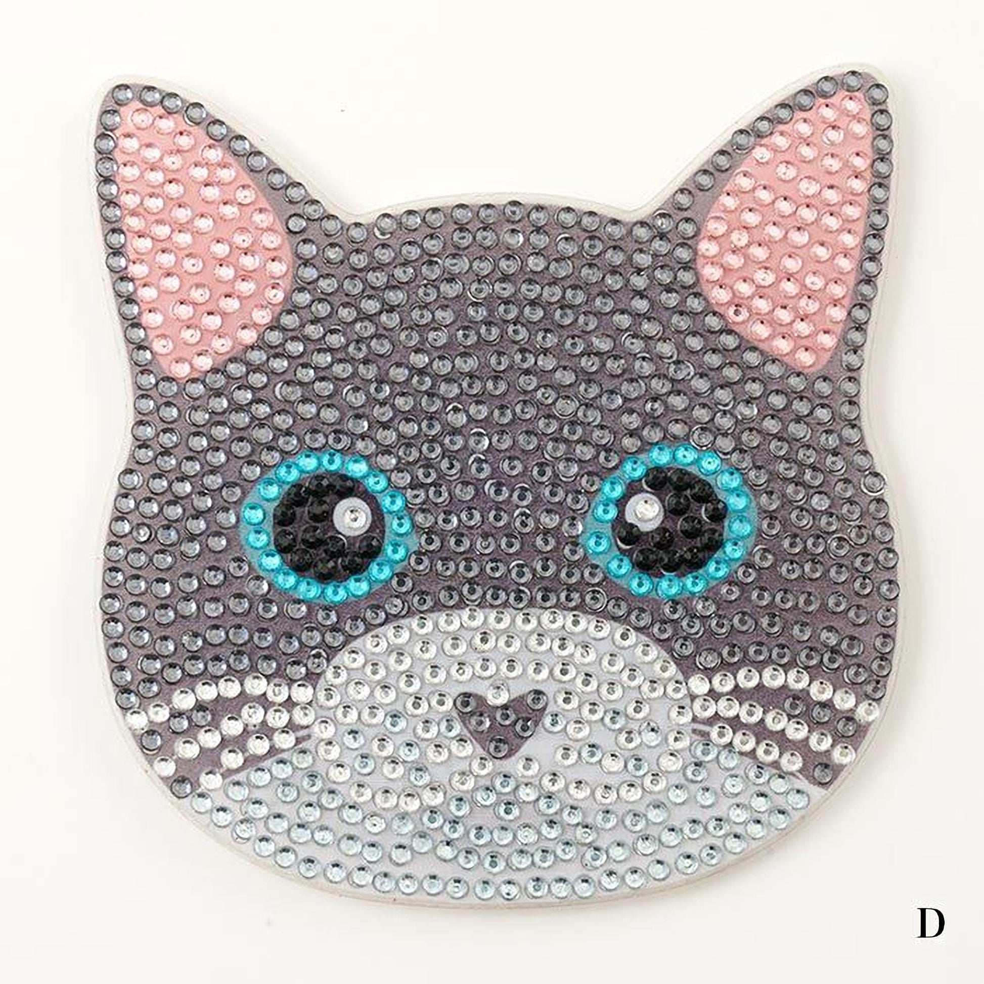 A close-up of a cat-shaped object made of small, colorful beads or sequins, with large blue eyes and pink ears.