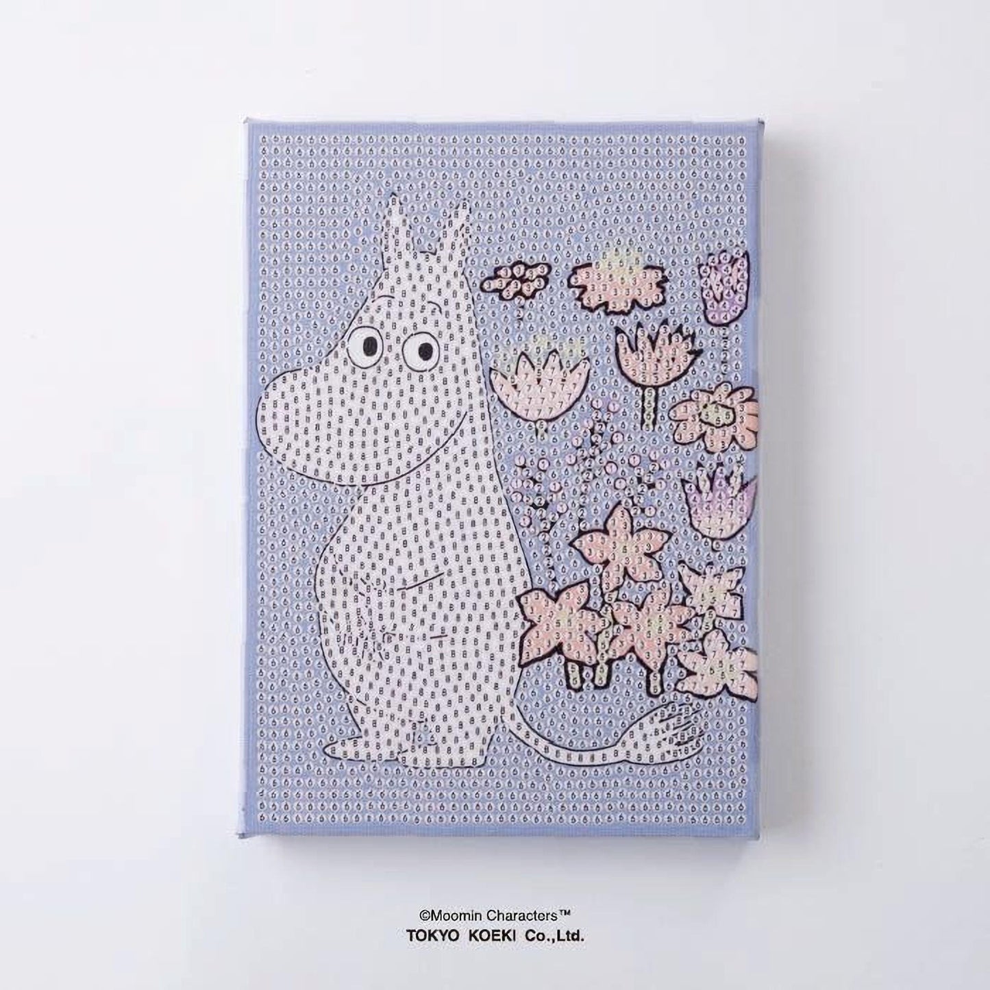 A canvas print featuring a cartoon character resembling Moomin from the Moomin characters series, with a background of various flowers and plants.