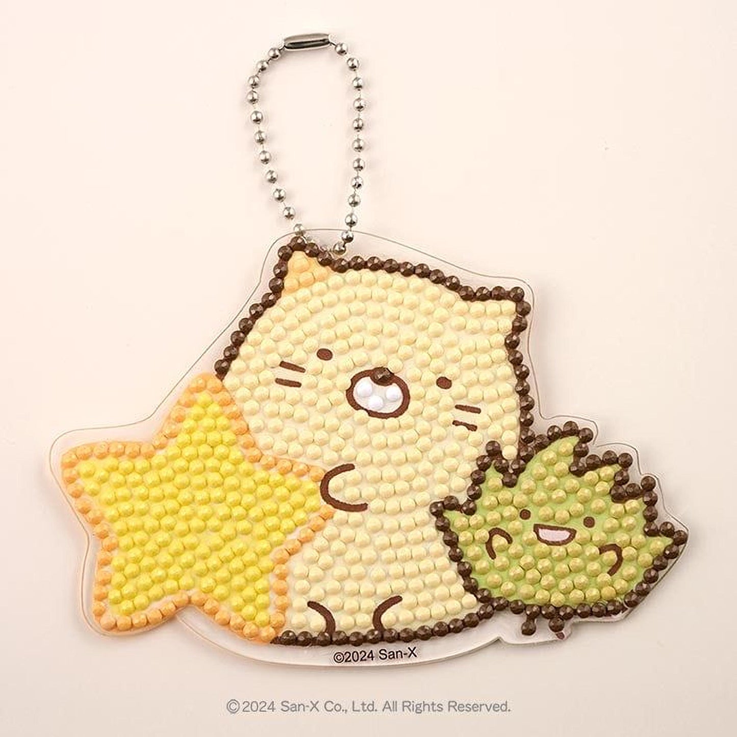 A keychain with a design made up of small beads or dots, depicting a cat and a star.