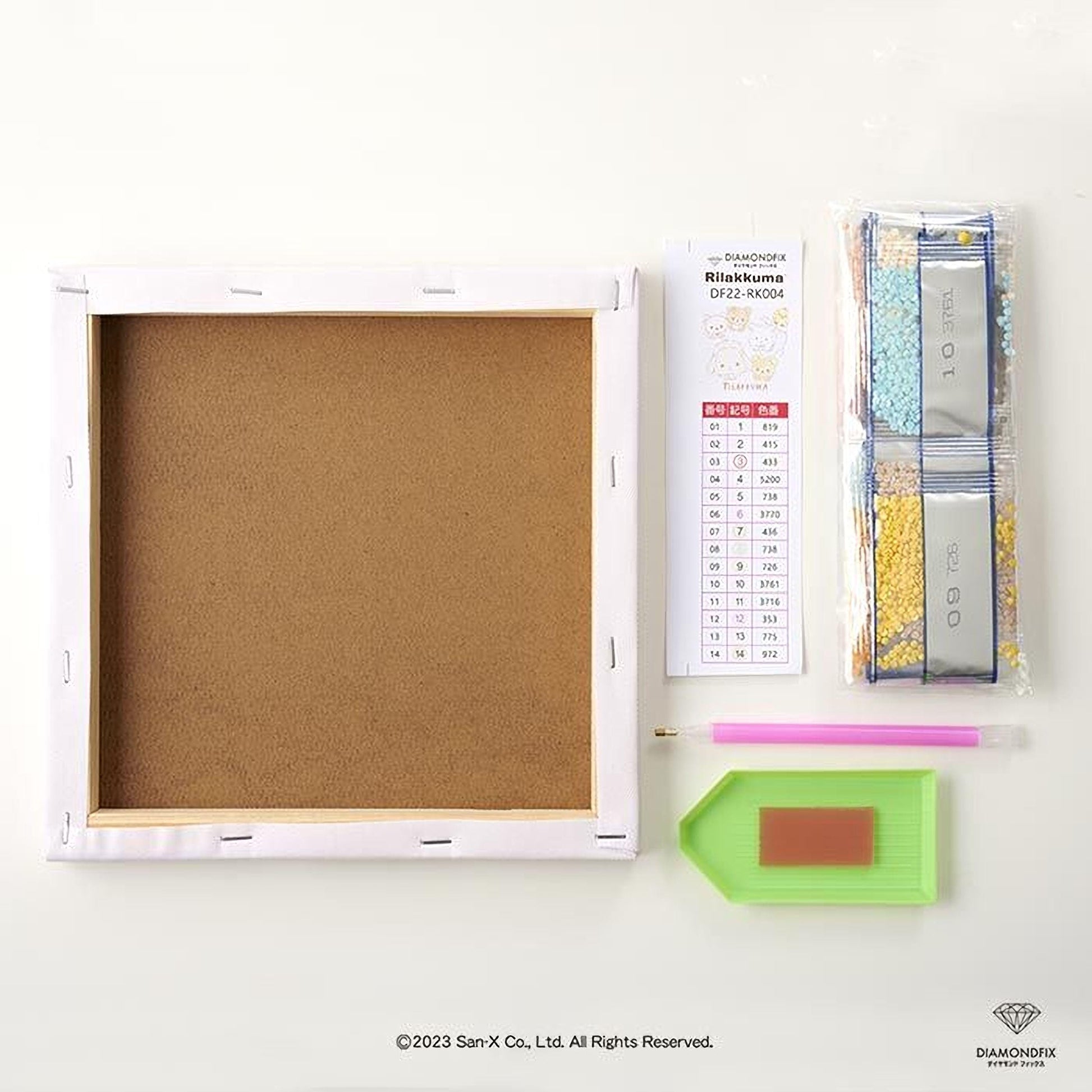 a blank canvas, a diamond kit, and some tools, all arranged on a white surface.