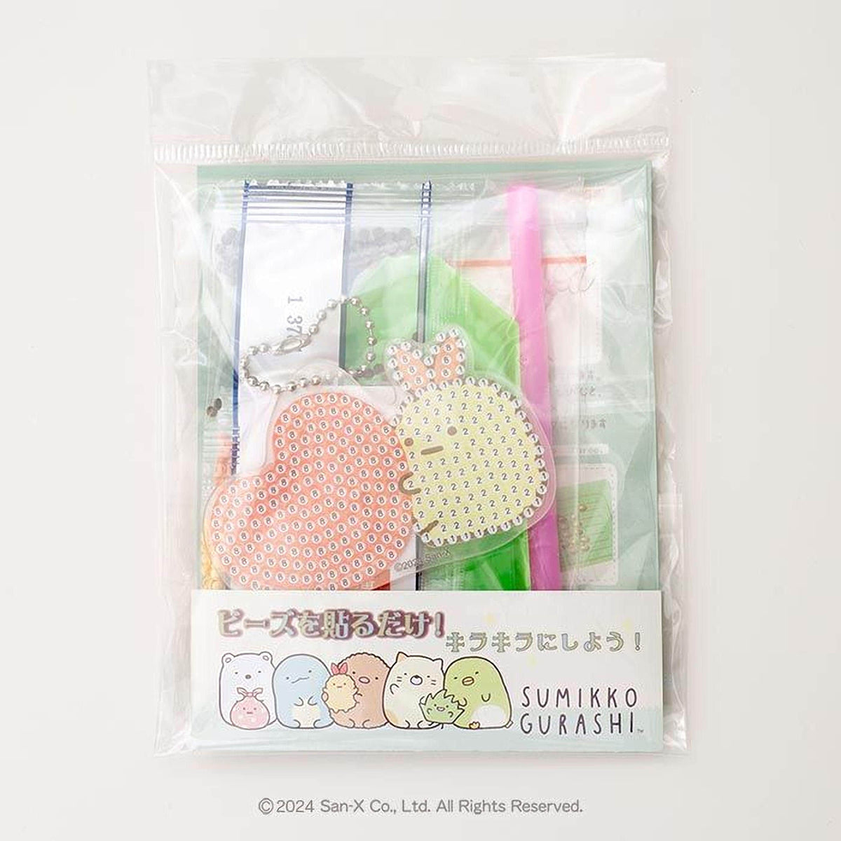 A clear plastic package containing a keychain and a pen, with a label featuring cartoon characters.
