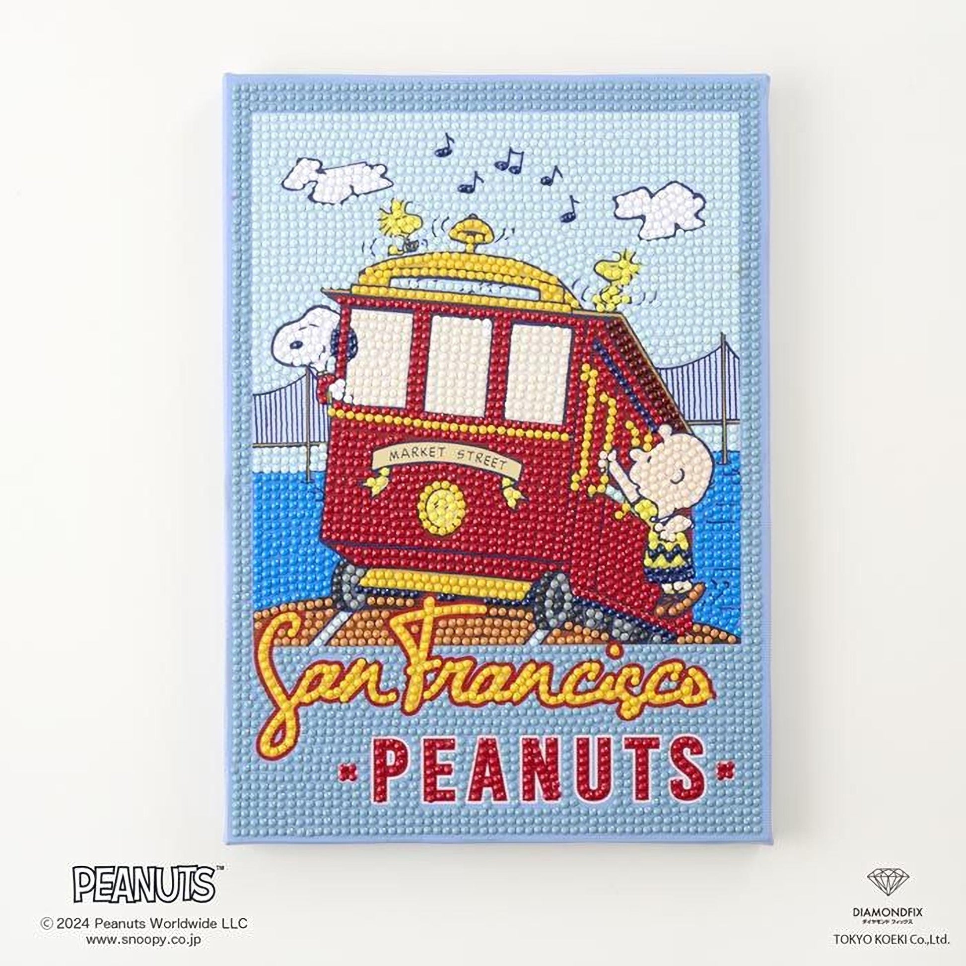The image is a framed piece of wall art featuring a cartoon image of a red trolley car with the text "San Francisco Peanuts" and a character from the Peanuts comic strip.